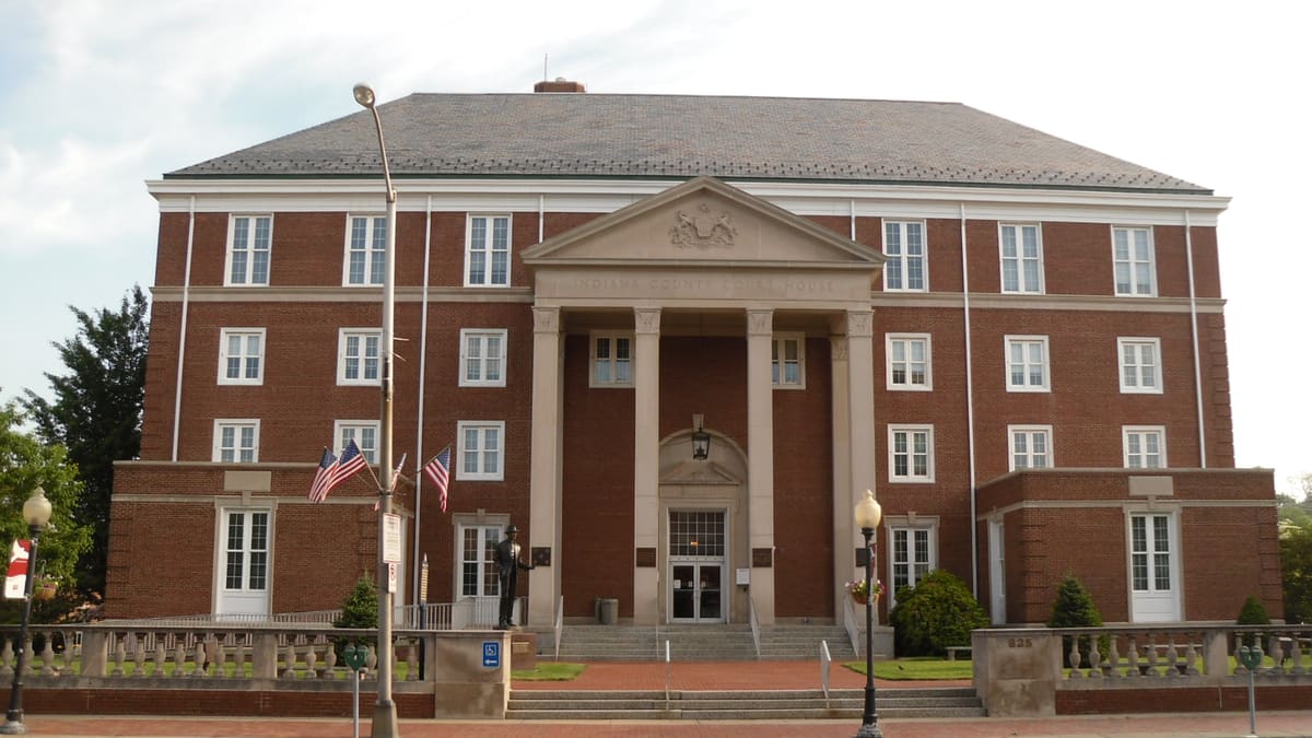 Red brick Indiana County Courthouse with a white columned entrance in Indiana, Pennsylvania.