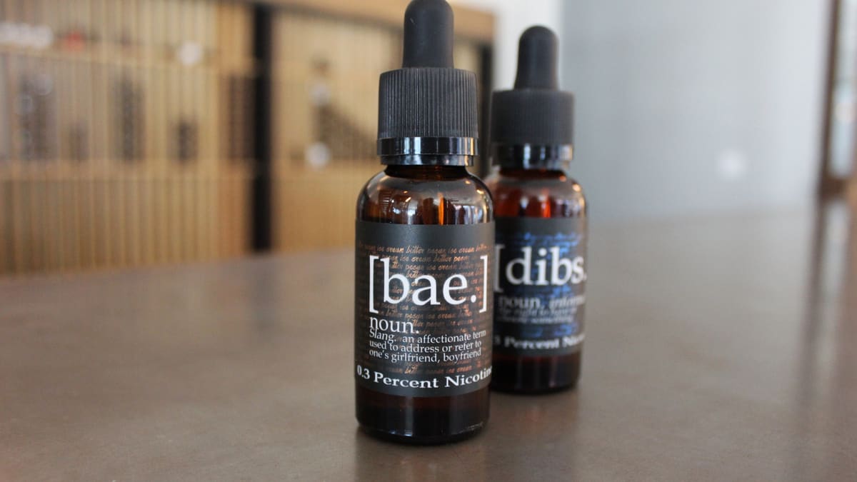 Two bottles of vaping liquid on a shop counter.